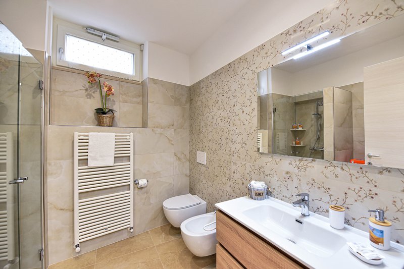 Bagno moderno con sanitari sospesi e box doccia in vetro