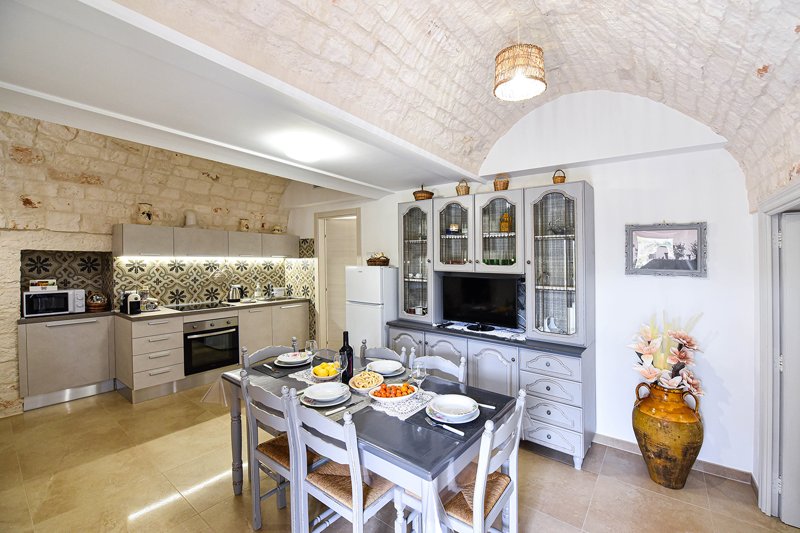 Ampio open space cucina soggiorno con volte in pietra tipiche dei trulli